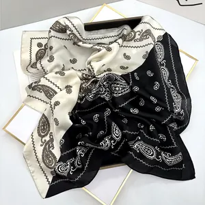 Detailed close-up of paisley pattern silk scarf in black and white two-tone design
