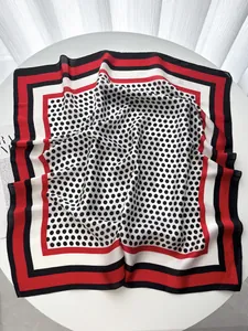Close-up of lightweight silk square scarf with classic red and black polka dot pattern