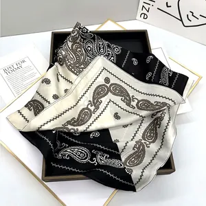 Macro shot of paisley pattern silk scarf folded elegantly on a black and gold tray
