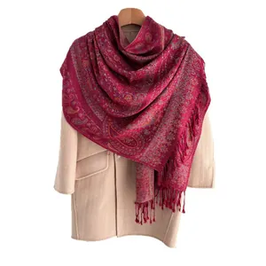Châle en cachemire motif paisley rouge foncé avec franges sur un manteau de laine