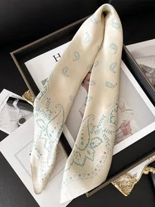 Détail d'un foulard en soie haut de gamme avec motif cachemire beige et texture lisse