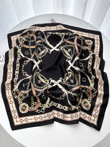 Detail of elegant black silk square scarf with golden chain and horse buckle patterns