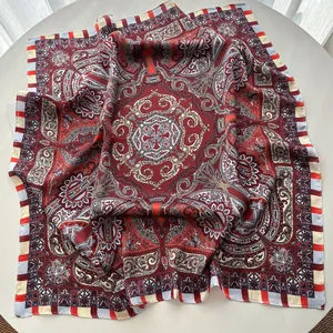 Detailed flat lay of a silk paisley square scarf with vintage red and navy mandala patterns
