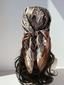 Detailed view of paisley silk scarf styled as an elegant headband on wavy hair