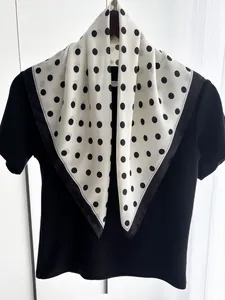 Detail of silk-like polka dot scarf showing the smooth texture and black border contrast