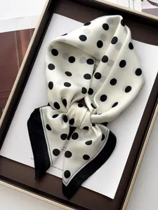 Detailed view of polka dot silk-texture scarf inside an elegant gift box presentation