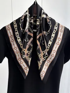 Detail of silk-feel scarf featuring golden chain horse motifs and satin finish luster