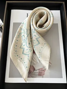 Détail d'un foulard en soie beige avec motif paisley bleu sur un magazine de mode
