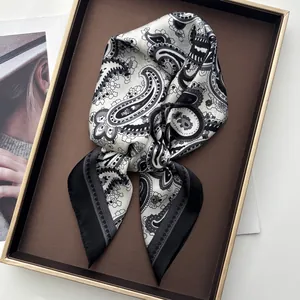 Classic paisley silk square scarf in black and white grey folded on a metal tray