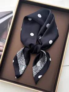 Detail of silk-feel scarf featuring white polka dots and leopard print texture in box