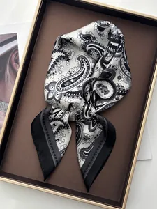 Detail of elegant black and white paisley silk scarf tied in a gift tray with a vintage pattern