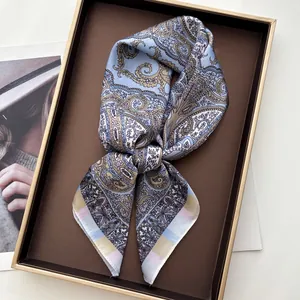 Close-up of blue paisley silk square scarf neatly folded in an elegant premium gift box