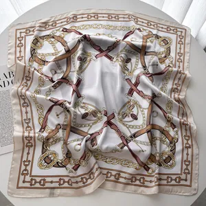 Detailed texture of silk scarf with gold chain and leather belt patterns on table