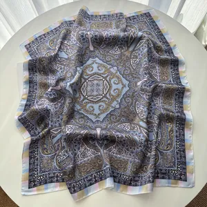 Detail of silk-like square scarf with paisley patterns and striped border on table