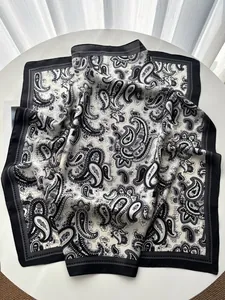 Macro shot of paisley silk scarf with black and white bohemian patterns on a table