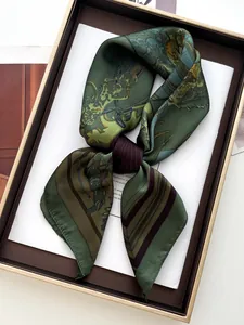 Detailansicht eines vintage dunkelgrünen Seidenschals mit Reitmuster und Geschenkbox