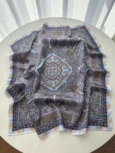 Macro detail of paisley pattern on light blue silk scarf with fine rolled edge stitching