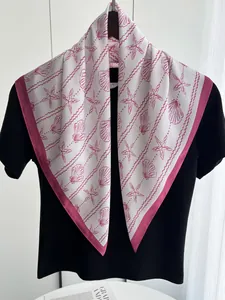 Detail of a silk scarf with pink starfish and seashell prints over a white base