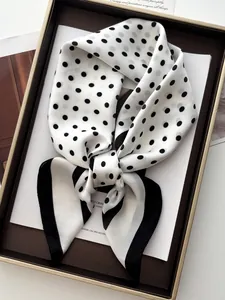 Detailed view of a classic black and white polka dot silk scarf in an elegant bow knot