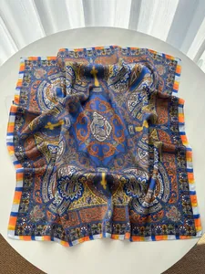 Macro view of silky square scarf featuring paisley prints and blue orange bohemian patterns
