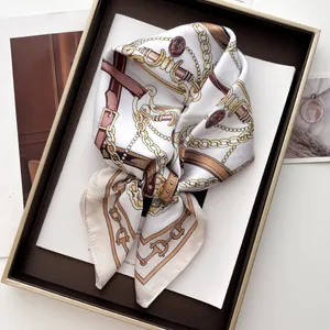 Detail of silk-feel square scarf featuring golden chain and equestrian leather belt prints