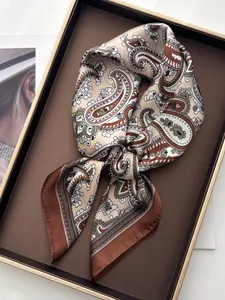 Close-up of paisley pattern silk scarf in earthy tones on a luxury display tray