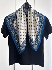 Detail of silk-like square scarf with blue paisley border and bee pattern on white base