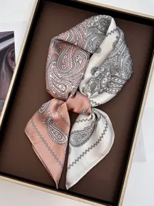 Detail of paisley silk scarf in peach and cream on a decorative golden tray