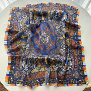 Detailed view of large satin square scarf featuring blue and orange paisley patterns