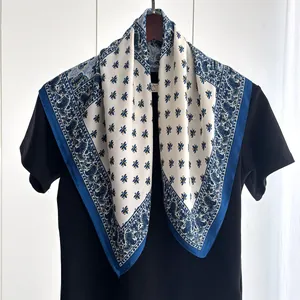 Detail of elegant paisley border and bee print on a navy blue silk-like square scarf
