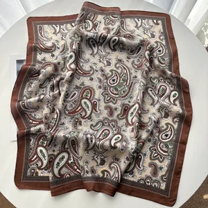 Detail of paisley silk scarf showing soft drapes and elegant brown patterns on a white table