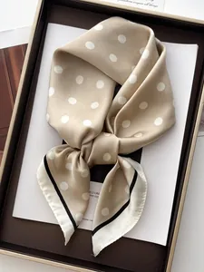 Macro detail of elegant beige polka dot silk scarf with black decorative borders