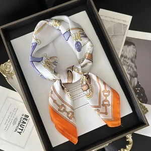 Detailed shot of a 70x70cm satin square scarf with chain print on a black display tray