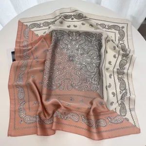 Detail of cream and dusty pink silk-like square scarf with intricate paisley pattern