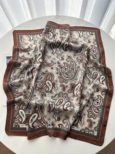 Close-up of a vintage paisley print silk-like scarf folded on a white round table