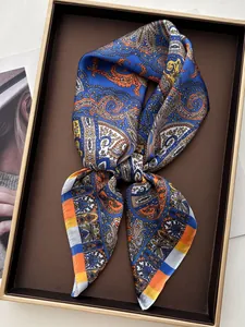 Detailed view of paisley silk scarf with blue and orange tones in premium gift box