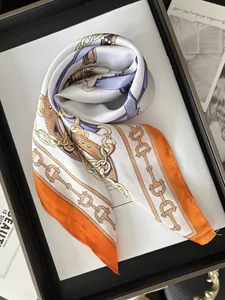Detail of silk-feel scarf with equestrian chain print and vibrant orange border design