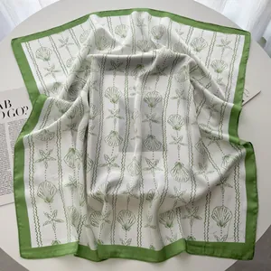 Detail of shell and starfish pattern on a green and white silk-feel square scarf