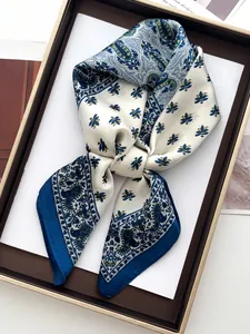 Close-up of printed paisley silk scarf neatly folded on a premium gold-trimmed tray