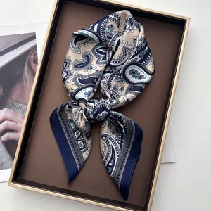 Detailed close-up of navy paisley silk scarf displayed on an elegant golden-rimmed tray