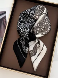 Macro detail of silk-like paisley square scarf with black and brown patterns