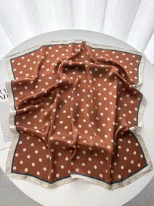 Detail of silk-like square scarf with white polka dots on caramel brown fabric