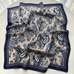 Detailed view of paisley silk scarf with deep blue borders and smooth satin texture