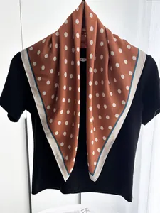 Close-up of caramel polka dot silk scarf draped on a mannequin with elegant finish