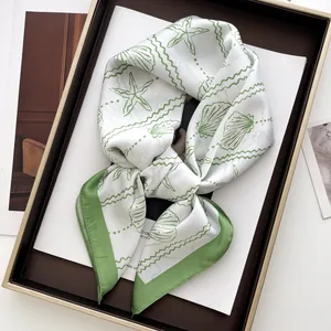 Detail of silk scarf with green starfish and shell prints in a stylish display tray