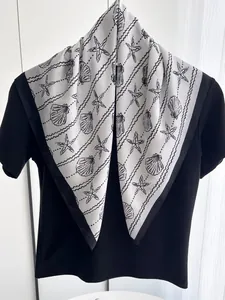 Close-up of shell and starfish pattern on premium black and white silk scarf texture