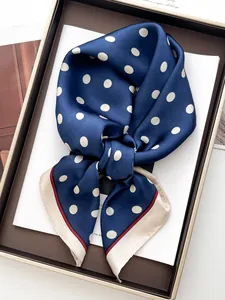Close-up of classic navy blue polka dot silk scarf in a premium gift box packaging