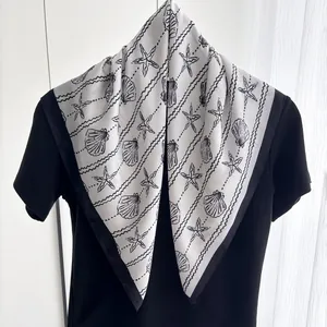Detail of silk scarf showing starfish shell prints and black borders on white fabric