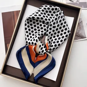 Classic polka dot faux silk scarf with contrast striped borders on a wooden tray