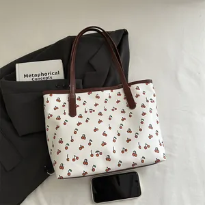 Sac cabas vintage imprimé cerises avec anses en cuir marron sur un blazer élégant
